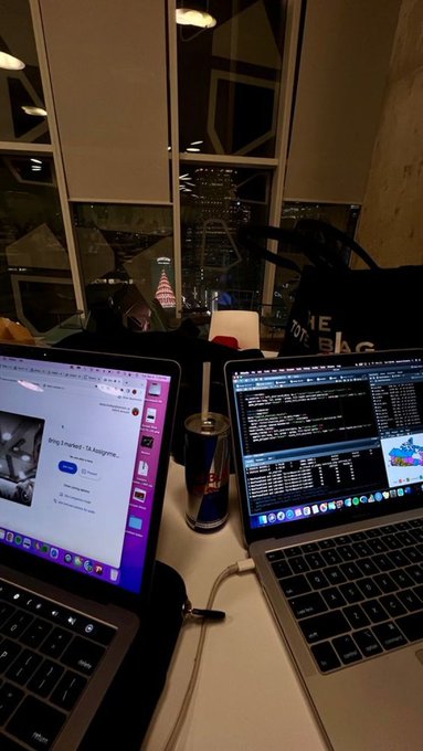 The image shows two laptops sitting side by side on a desk, both open and displaying web pages. The laptop on the left has a photo of a person on its screen, while the other laptop displays an advertisement for crypto mining. A cup is also present on the desk next to one of the laptops. The post suggests that if users have enough time and internet access, they can earn $100 daily by mining cryptocurrency like Bitcoin or Ethereum. It also mentions that there are apps available that pay users for their time spent mining.
