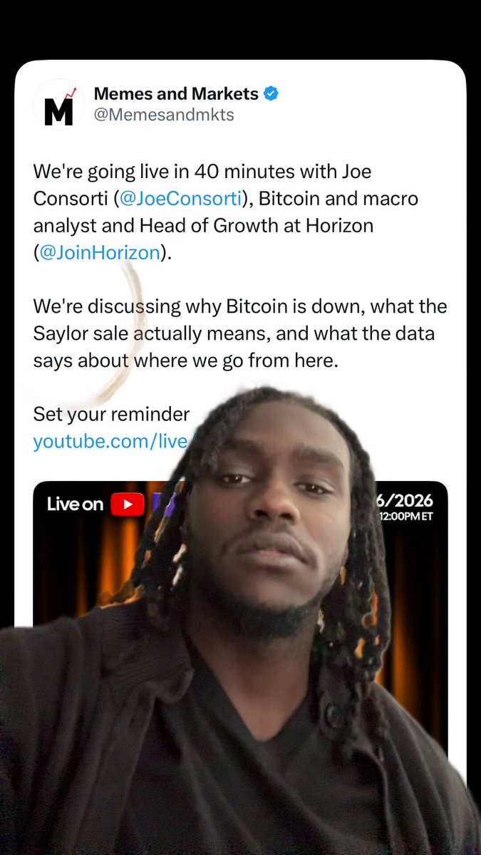 The image shows a man with dreadlocks wearing a black shirt, looking at the camera while holding up his phone displaying a Twitter account. The text on the screen reads "We're going live in 40 minutes with Joe Conson (Joe Conrad)". This suggests that the man is about to share some information or news related to Bitcoin and Joe Conrad's involvement in it.