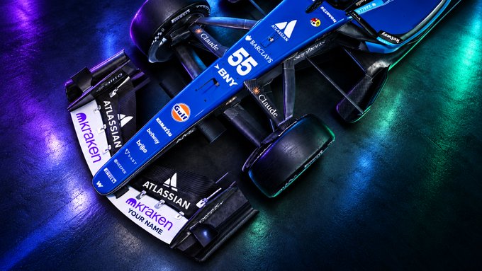 A Williams Formula 1 car (number 55) features prominently with visible sponsor logos including Atlassian, Kraken, Barclays, Gulf, BNY, Citrix, Komatsu, and "Your Name" placeholder text on the front wing, aligning with Kraken's promotion offering entrants a chance to have their name displayed on the front wing at the Mexico City GP alongside the other branded elements visible on the car.