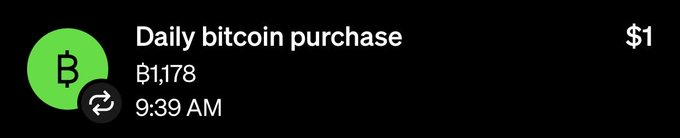 A mobile notification showing a daily bitcoin purchase of ₿1,178 for $1, timestamped at 9:39 AM with a green Bitcoin icon.