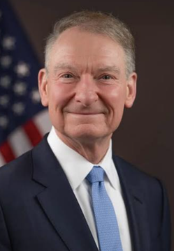 Former SEC Commissioner Paul Atkins pictured smiling in an official portrait with the American flag behind him, though the image does not directly depict the crypto custody rule overhaul mentioned in the post.