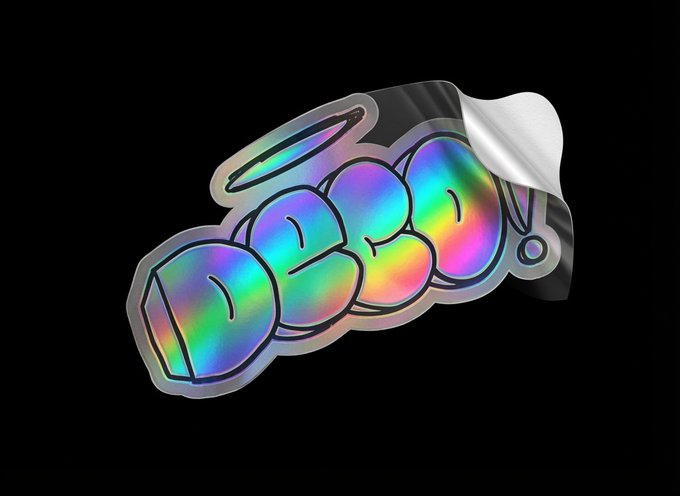 A holographic, iridescent sticker with a graffiti-style design being peeled from its backing against a black background.