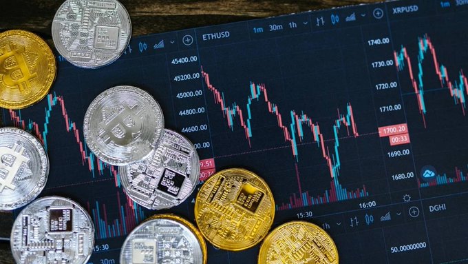 Physical Bitcoin replica coins rest atop a digital trading chart displaying ETHUSD price action climbing from around 1680 to past 1740, visually illustrating the article's theme of a crypto market recovery that added over $120 billion in value.