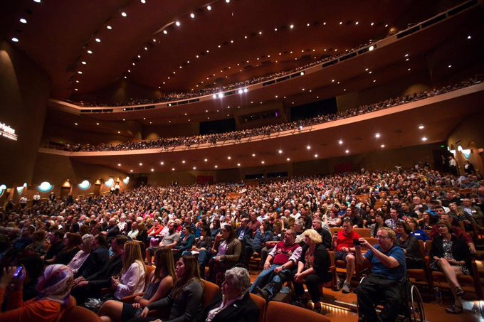 A packed concert hall with thousands of people attending a live event, illustrating the scale of an audience compared to the 3,500 active NFT traders mentioned in the post.