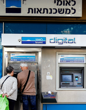 Two customers stand at an ATM of Bank Leumi (לאומי) in Israel, which the post announces will soon offer Bitcoin trading to its 2.5 million clients, with a launch planned for early 2027.