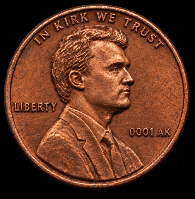 A copper-colored coin features a profile portrait of a man with the inscriptions "IN KIRK WE TRUST" along the top edge, "LIBERTY" on the left, and "0001 AK" on the right, parodying a U.S. penny. The image ties to the $PENNY meme token by visually riffing on the "penny" theme while adding a humorous "Kirk" twist, reflecting the playful, community-driven nature of the cryptocurrency.