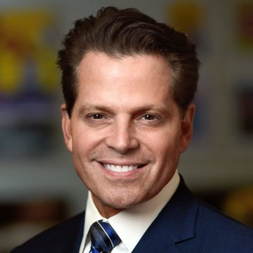 A professional headshot shows Anthony Scaramucci, a man with short dark hair wearing a dark suit, white shirt, and patterned tie, smiling at the camera against a blurred office background. The image accompanies his bullish Bitcoin price prediction, lending his financial credibility to the forecast that BTC will rally in late 2026 into early 2027.