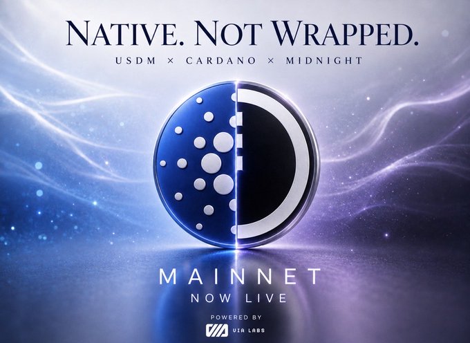 A promotional graphic for USDM's mainnet launch on Midnight, featuring a split blue-and-black circular logo (Cardano/Midnight branding) surrounded by flowing purple cosmic waves, with the headline "NATIVE. NOT WRAPPED." and text reading "USDM × CARDANO × MIDNIGHT" and "MAINNET NOW LIVE — POWERED BY VIA LABS."

The image visually reinforces the post's core message by contrasting "Native. Not Wrapped." against a split Cardano/Midnight emblem, symbolizing USDM's seamless, bridge-free movement between the two chains.