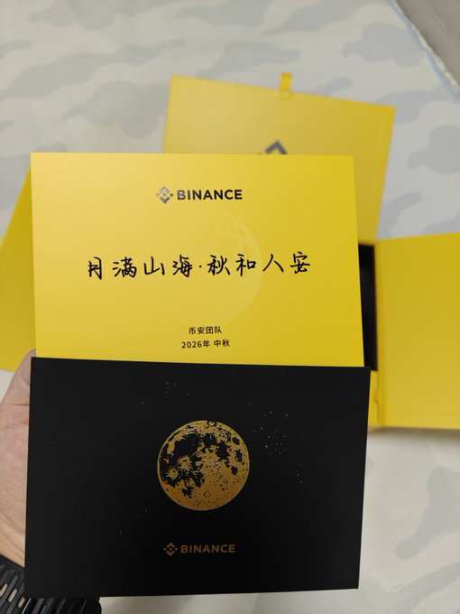 A Binance-branded yellow and black Mid-Autumn Festival gift card featuring a moon illustration and the Chinese text '月满山海·秋和人安', from 西安团队 dated 2026 中秋.