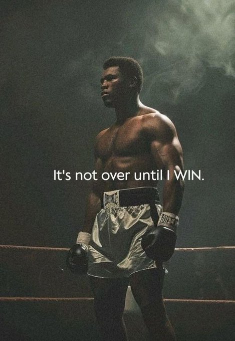 A dramatic photo of a shirtless boxer in white trunks standing in a smoky ring with the motivational quote "It's not over until I WIN." overlaid in white text.