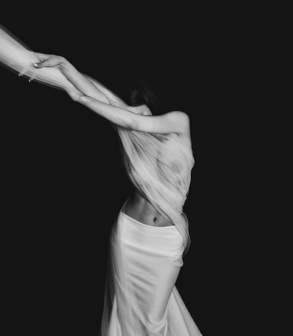 This is a black and white self-portrait of a person wrapped in flowing fabric against a dark background, embodying the "Holding on" collection with only 33 XTZ editions remaining.