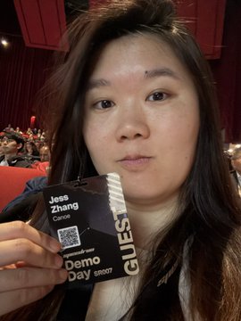 A selfie of a person holding a guest badge that reads 'Jesse Zhang, Demo Day, GUEST, ON.'