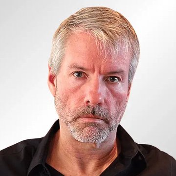 The image features a man with gray hair wearing a black shirt, looking directly at the camera with an intense expression. The caption below the photo reads "JUST NOW: MICHAEL SAYLOR TEASES NEW $BTC PURCHASE VIA X". This suggests that Michael Saylors is promoting a new cryptocurrency called Bitcoin and is encouraging people to invest in it by using his image as part of the marketing campaign.

The man's intense expression could be interpreted as him being passionate about Bitcoin or trying to convey its potential benefits, such as financial gains from investing in this digital currency. The post seems to be targeting a younger audience who might be interested in cryptocurrency and eager to learn more about it.