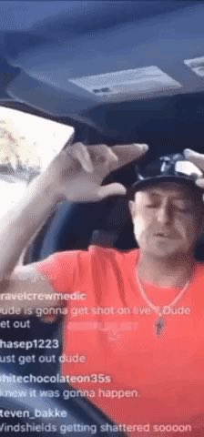 A man in a red shirt and black cap sits in a car during a livestream, holding up a hand gesture, with comments like 'Dude is gonna get shot on live' and 'windsields getting shattered sooon' visible.