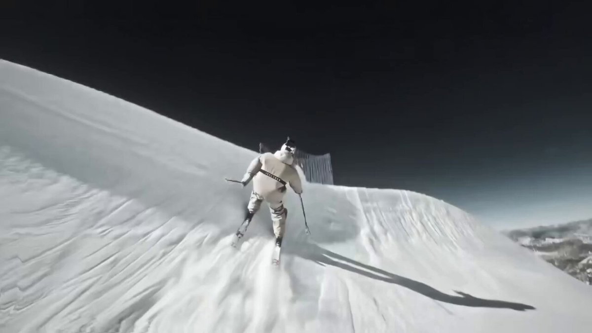 The image shows a person skiing down a snow-covered slope, wearing skis and holding ski poles. The scene captures the motion of the skier as they descend the hill at high speed. The photo has been edited with a filter that gives it a black and white appearance, adding an artistic touch to the scene. The caption below the image reads "$motion on the motion chain then $NEET because no one wants to work until they are too old to enjoy retirement". This message seems to be related to the skiing activity in the photo, possibly encouraging people to take up skiing as a form of exercise and leisure activity at any age.