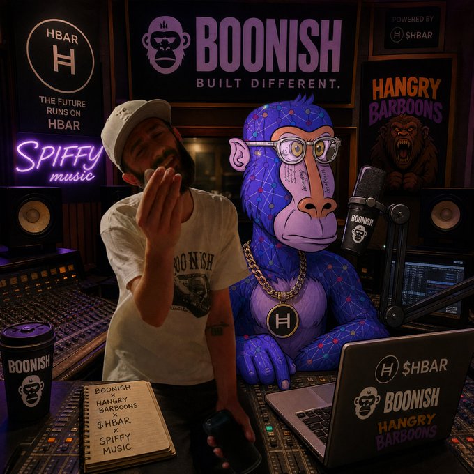 A promotional image for BOONISH featuring a man with a beard and white cap blowing a kiss alongside a blue/purple geometric gorilla figurine, set in a recording studio with neon signs reading 'HBAR - The Future Runs on HBAR' and 'SPIFFY music.'