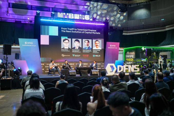 A photograph of a panel discussion at 'MYBW 6' (Malaysia Blockchain Week), with four speakers seated on stage in front of a screen titled 'From TradFi to Tokenized Finance: The Next Evolution of Capital Markets' and 'DFNS Institutional Crypto' branding.
