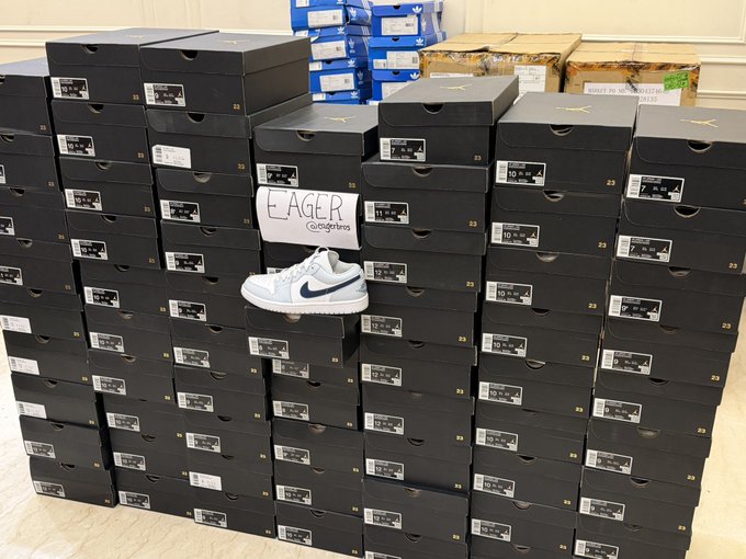 A large stack of black Nike shoe boxes (labeled size 10) fills the frame, with a single light blue and white Nike sneaker displayed in front alongside an "EAGER soleRetriever" card, suggesting a profitable resale haul. The "another beautiful day to keep winnin'" caption reflects the success of acquiring and reselling this bulk inventory of shoes.