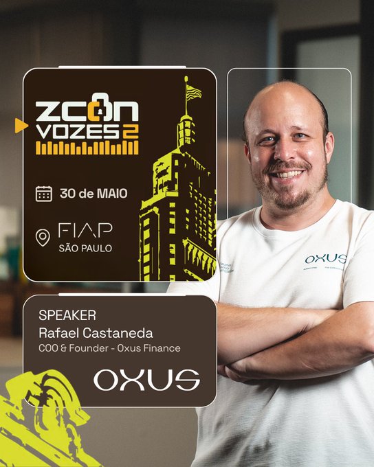 The image features a man standing next to a poster for Zcon Vozes 2, which is an event related to cryptocurrency. The poster has a picture of a building with a flag on top, indicating that the event might be taking place in a city with a significant history or cultural importance. The man's smiling expression suggests he is excited about attending the event and sharing his thoughts on the topic.