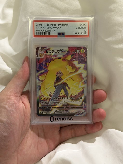 A hand holds a PSA-graded Pokemon card featuring Pikachu VMAX from the 2021 Japanese SWSH set, card #223, with a GEM MT 10 rating and certification number 138112418.
