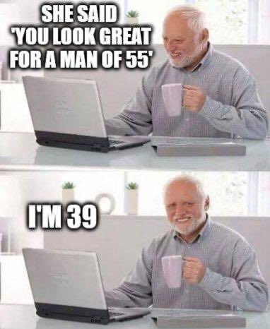A two-panel meme shows a smiling older man with a laptop and coffee mug, first looking surprised with the text "SHE SAID 'YOU LOOK GREAT FOR A MAN OF 55'" and then grinning with "I'M 39," humorously implying he appears much older than his actual age.