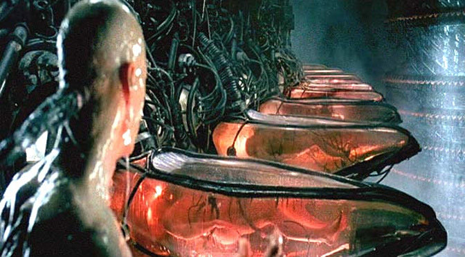 A scene from a science fiction film showing a humanoid figure looking at rows of glowing, translucent pods containing small creatures.