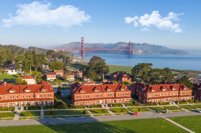 The iconic Golden Gate Bridge rises over the San Francisco Bay, with the historic red-brick Presidio buildings in the foreground, perfectly symbolizing the launch of the new Presidio Bitcoin Visiting Member Program inviting builders and freedom-tech advocates to spend 1-3 months in this iconic SF location alongside ~30 like-minded innovators.