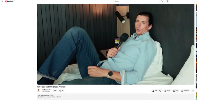 A screenshot of a YouTube video titled "Italy Has a SERIOUS Bitcoin Problem" by Joe Nakamoto, showing a man in a light blue shirt reclining on a bed while speaking into a microphone. The video, which has 598K views and was posted 1 day ago, relates to the accompanying post about the "Bitcoin Italian problem" that Joe Nakamoto is addressing.