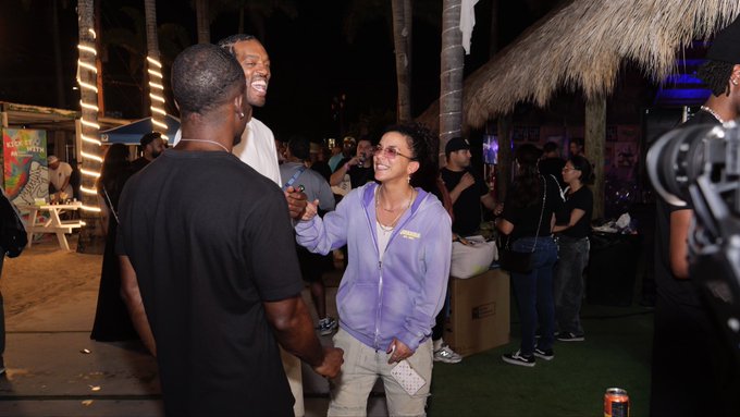 A person wearing a purple "Invisible Friends" hoodie with sunglasses pushed up is animatedly greeting someone at an outdoor night event, surrounded by a crowd near a thatched-roof structure.

The image captures the IRL event-hosting experience referenced in the post, visually reinforcing the claim of personally running in-person web3 meetups through genuine, grassroots community engagement rather than polished PR.