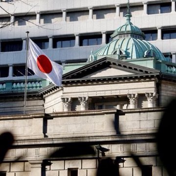 The Japanese flag (also called Hinomaru) flies atop a classical building with a green dome, likely the Bank of Japan headquarters in Tokyo. The image relates to the "Rct" (rate cut) caption by symbolizing Japan's economic and monetary policy context.