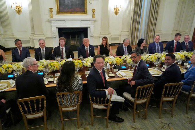 President Donald Trump hosts a White House dinner with leaders of major cryptocurrency companies including Coinbase, Ripple, Gemini, Robinhood, and Polymarket, with Elon Musk seated prominently in the center facing the camera.