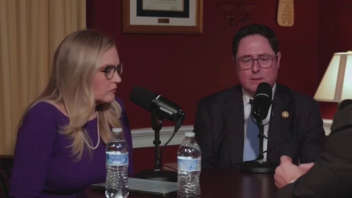 The image shows two people sitting at a table, each holding a microphone, likely participating in a podcast or radio show. The hosts are wearing purple shirts, which suggests that this could be an event related to cryptocurrency or digital assets. A water bottle is placed on the table between them, indicating they might have been discussing the topic for some time. The image also contains text that reads "Most people still think $TEL is a small crypto project. They're not paying attention", which implies that the hosts are addressing a common misconception about Telcoin Paul and his involvement with cryptocurrency projects.