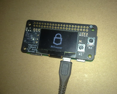 An Adafruit PiTFT 1.3" 240x240 IPS display module shows a lock icon and 'PiTrefer' text, connected via a USB cable against a cardboard background.