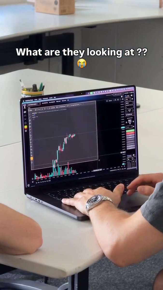 A person is working on a laptop displaying a financial candlestick chart, with text overlay asking 'What are they looking at??' accompanied by a crying emoji.