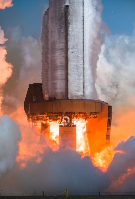 A SpaceX Starship rocket ignites its engines during a test launch, billowing massive clouds of fire and smoke against a dramatic sky. The image visually reinforces the post's reference to Elon Musk and SpaceX's ambitious projects, symbolizing the epic and powerful nature of the "Prometheus" meme coin narrative tied to Musk's ventures.