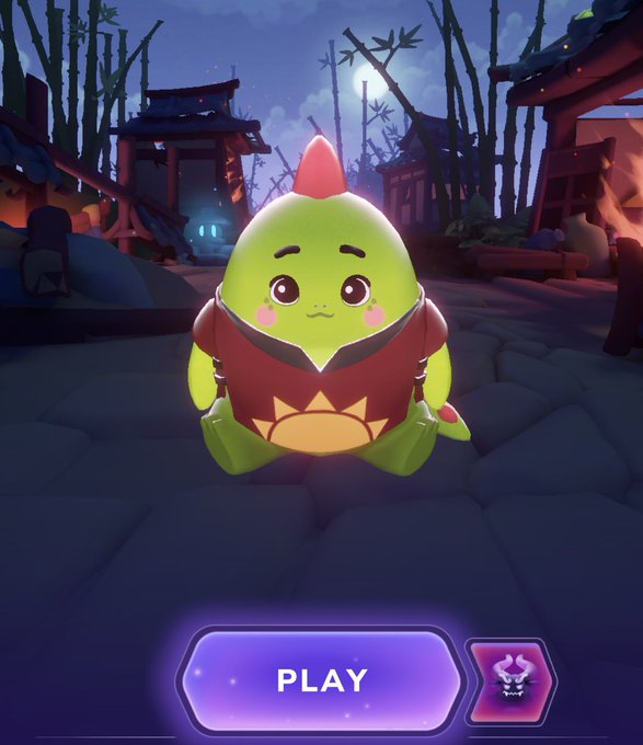 A mobile game start screen featuring a cute green cartoon dragon-like creature wearing a red outfit in a bamboo forest setting, with a 'PLAY' button below.
