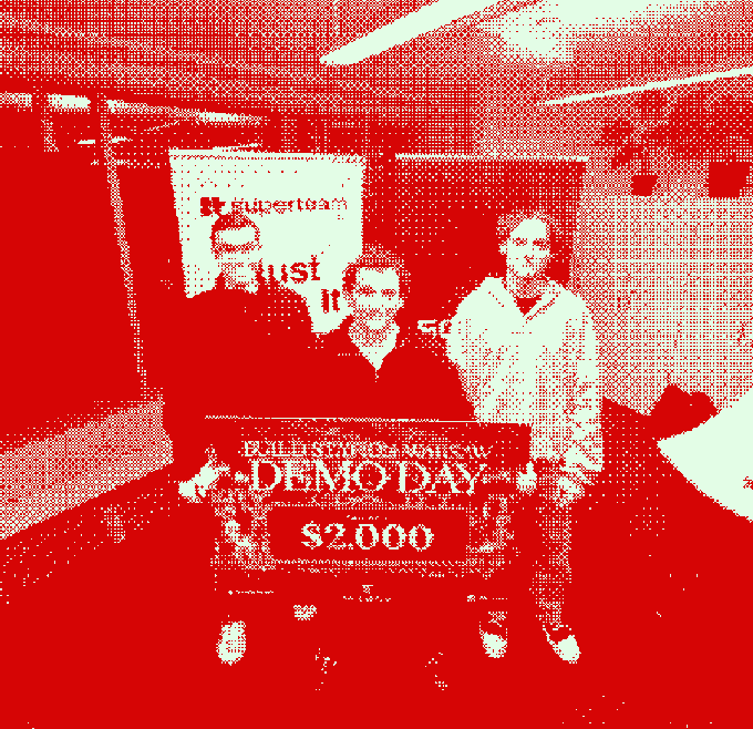 Two people pose with a "DEMO DAY" check for $2,000 from Billstartup Demo Day by Superteam, related to the post about judging the Colosseum demo day event hosted by @SuperteamPOL.