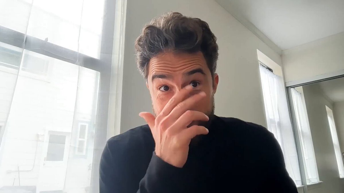 The image features a man wearing a black sweater with his hand covering his face as he looks at the camera. The background of the photo shows a window, suggesting that they are indoors or possibly taking place in an office setting. The caption of the image reads "Ep. 85 of @TokenizedPod : The First Bank Issued Stablecoin @sytaylor & @cuysheffield are joined by: @RegenRene , Co-Founder, @Celo Charles Hamel, Head of Product, @MiniPay, @Opera To discuss: Visa CLI onboarding merchants and US rollout Cash App supports fee".