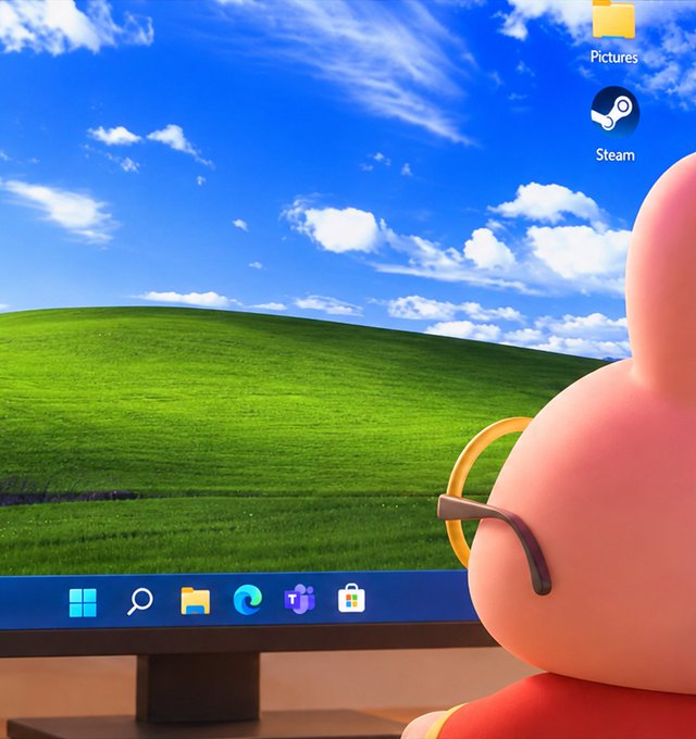 A pink rabbit character peers at a Windows desktop screen displaying the iconic "Bliss" wallpaper with its rolling green fields and blue sky, alongside visible taskbar icons and desktop shortcuts for "Pictures" and "Steam." The image humorously illustrates the post's caption "Just opening a window," referencing both the literal act of viewing the Windows operating system and the play on words connecting to PancakeSwap's "Mystery Stock #38."