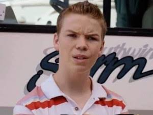 A young man in a white and red striped polo shirt appears to be speaking in front of a vehicle with partial text visible.