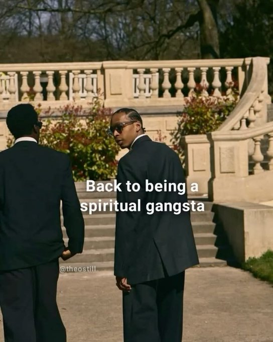 Two men in black suits standing on stone steps with the text 'Back to being a spiritual gangsta' and a watermark '@theost111'.