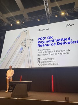 A speaker stands on stage presenting at an Algorand event with a large screen reading '200: OK Payment Settled, Resource Delivered' featuring Brian Whippo, Senior Director, Integrations & Developer Tools @ Algorand (@brianwhippo).
