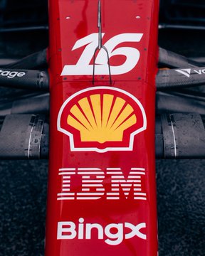 A close-up of a red Formula 1 car features sponsor logos including '16', a yellow Shell logo, 'IBM', and 'BingX'.