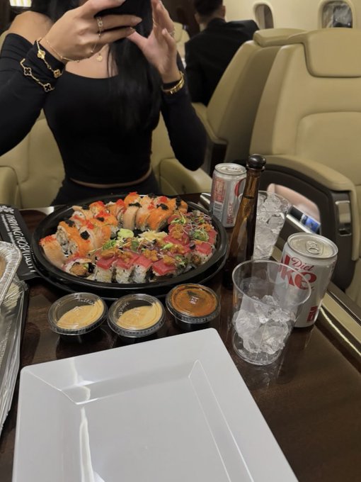 A person takes a mirror selfie at what appears to be an upscale restaurant, showing a large platter of assorted sushi rolls, Diet Coke cans, dipping sauces, and an empty white plate on the table.

The image of a luxurious sushi meal appears to be used as eye-catching bait for a giveaway promising to send $90 to a new follower—a common social media tactic to gain engagement that likely doesn't reflect the poster's actual wealth.