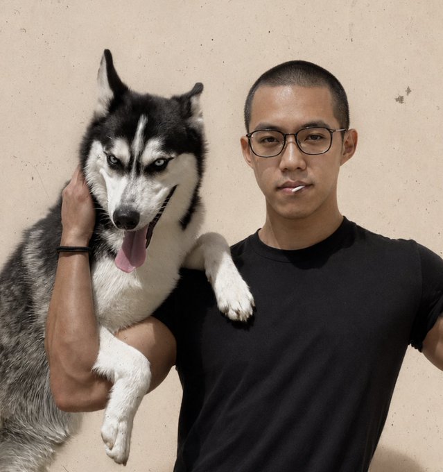 A photograph of a young man wearing glasses and a black t-shirt holding a large black and white Siberian Husky with striking blue eyes.