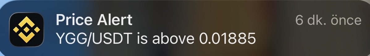 A price alert notification from Binance reading "YGG/USDT is above 0.01885" sent 6 minutes ago, shown in opposition to the post's preference for $XAI over $YGG in the gaming sector.