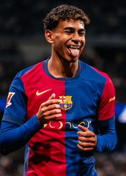 A young soccer player wearing a red and blue Barcelona FC jersey (with Nike and Beko sponsor logos) smiling and gesturing with his hands.