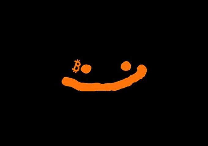 A simple orange smiley face graphic on a black background, with the Bitcoin 'B' symbol replacing one eye.