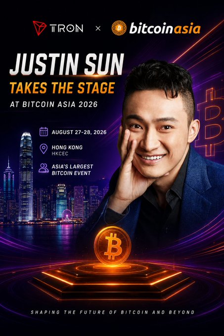 The image features a man posing for a photo, smiling at the camera while wearing a blue suit. The background of the image shows a city skyline with tall buildings, including one that has "TRON DAO" written on it. The text in the image reads "Justin Sun takes the stage @ Bitcoin Asia 2016", indicating that the event is related to cryptocurrency and the man is likely a prominent figure or expert in the field.