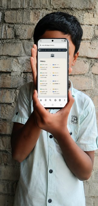 A young person in a light green button-up shirt holds a smartphone displaying the Allbridge history page (allbridgehistory) against a brick wall background, showing multiple successful USDC-BNB swaps that visually reinforce the post's praise of the app's smooth bridging interface.